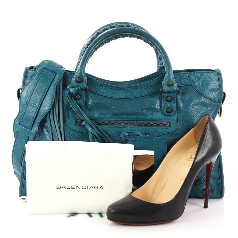 This authentic Balenciaga City Classic Studs Handbag Leather Medium is for the on-the-go fashionista. Constructed in blue leather, this popular bag features dual braided woven handles, front zip pocket, iconic classic studs and buckle details,