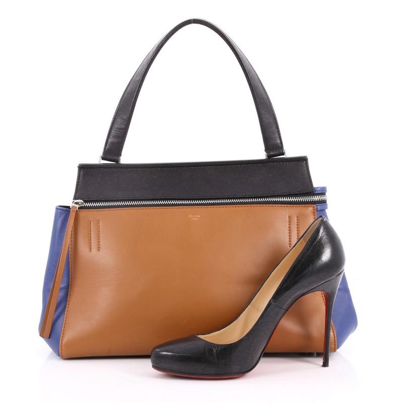 This authentic Celine Edge Bag Leather Medium is the quintessential Celine design mixing minimalism with luxury. Crafted in brown, black and blue leather, this bag features an exterior back pocket, single looped shoulder strap, gold stamped Celine