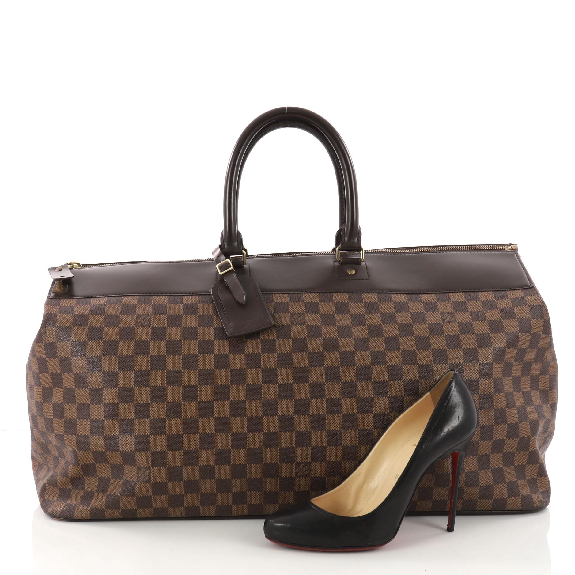 This authentic Louis Vuitton Greenwich Travel Bag Damier GM is the perfect travel companion that combines style and functionality. Constructed in classic damier ebene coated canvas, this structured tote features dual-rolled leather handles, dark