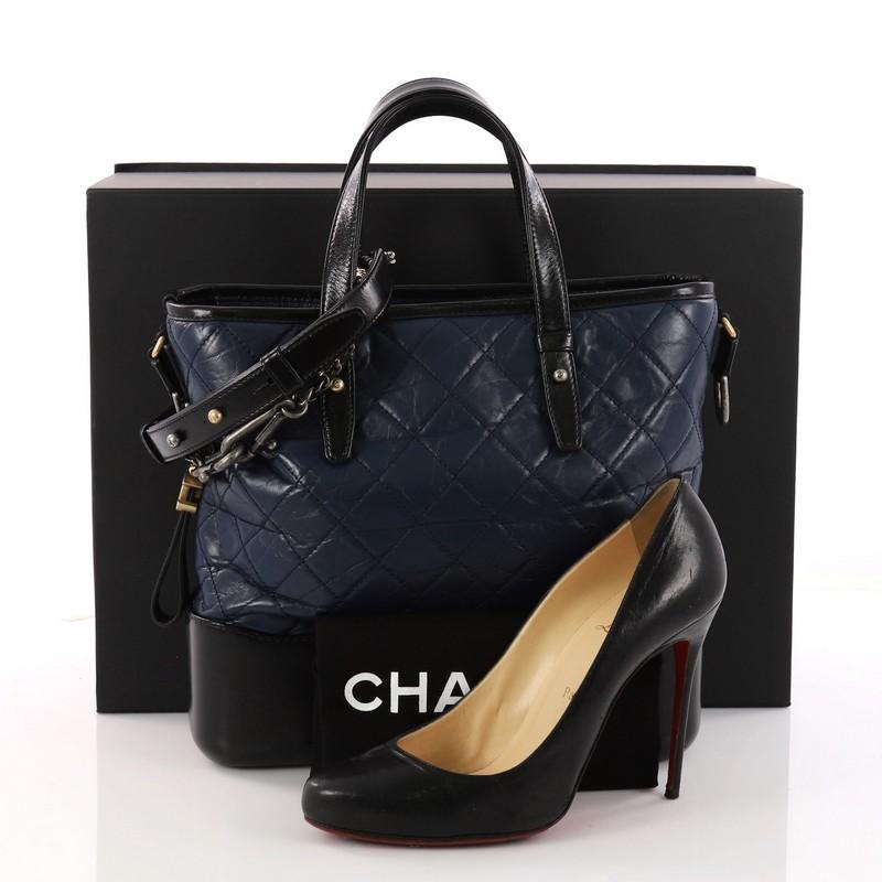 This authentic Chanel Gabrielle Shopping Tote Quilted Calfskin Medium displays a luxurious design with timeless modernity. Crafted from quilted navy aged calfskin, this tote features dual flat leather handles, gradient gold to aged silver woven-in