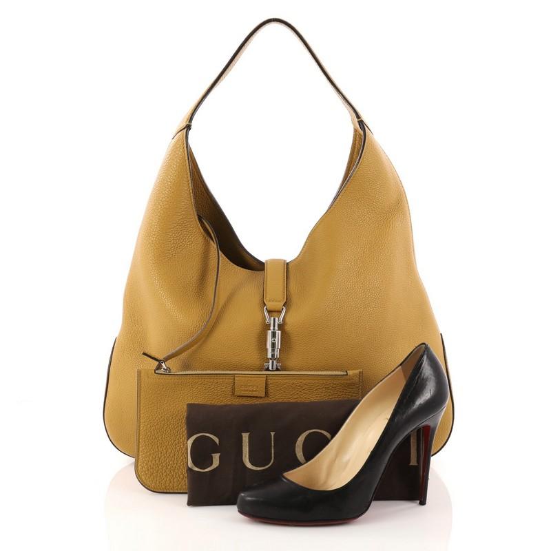 This authentic Gucci Jackie Soft Hobo Leather is a modern and clean representation of its classic Jackie bag. Crafted from honey mustard leather, this luxurious, no-fuss hobo features a single loop leather handle, subtle imprinted Gucci logo at the