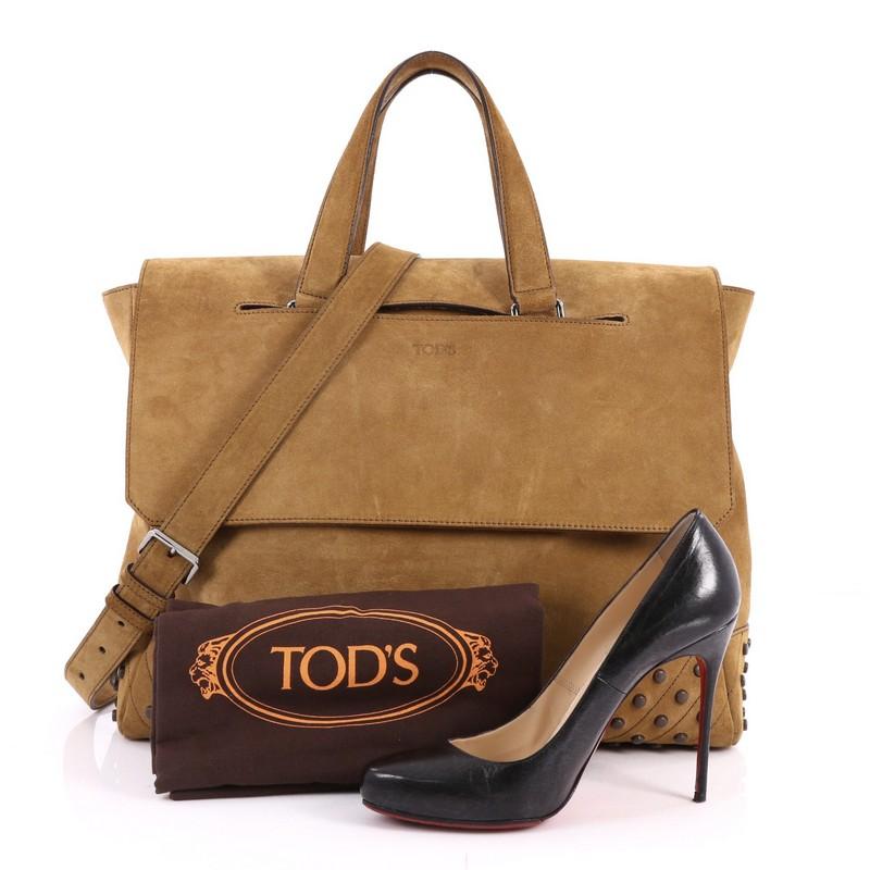 This authentic Tod's Envelope Convertible Tote Suede Medium is a chic bag perfect for the everyday excursions. Crafted in brown suede, this minimalist bag features dual-flat suede handles, detachable strap, stamped Tod's logo on the front flap,