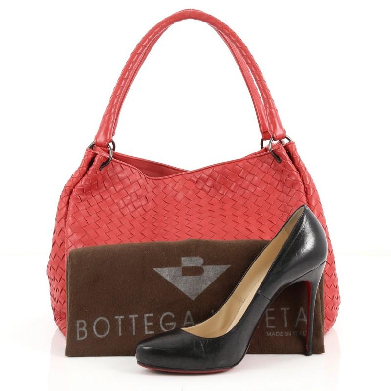 This authentic Bottega Veneta Parachute Handbag Intrecciato Nappa Medium is an iconic bag that combine functinality and impeccable construction. Crafted in red leather in Bottega Veneta's signature intrecciato woven method, this stylish bag features
