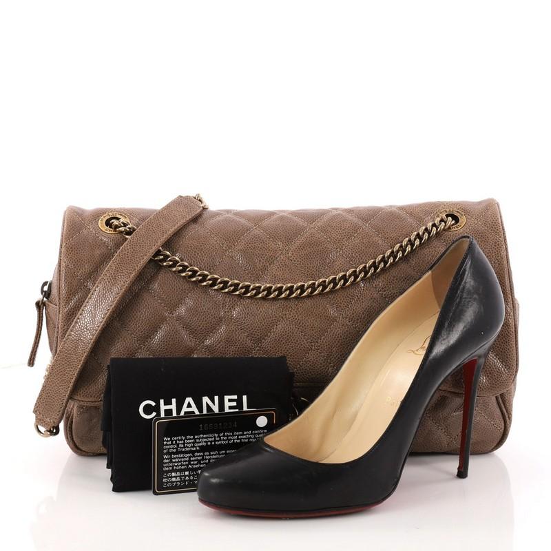 This authentic Chanel Shiva Flap Bag Quilted Caviar Large exudes a classic yet easy style made for the modern woman. Crafted from brown caviar leather with Chanel's signature diamond quilting design, this elegant flap features woven-in leather chain