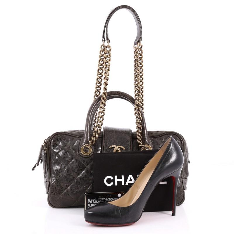 This authentic Chanel Shiva Bowler Bag Quilted Caviar is a marvellous bag, ideal for day or evening use. Crafted in dark green quilted caviar leather, this stylish bag features chain-link shoulder strap with leather pads, dual-rolled leather