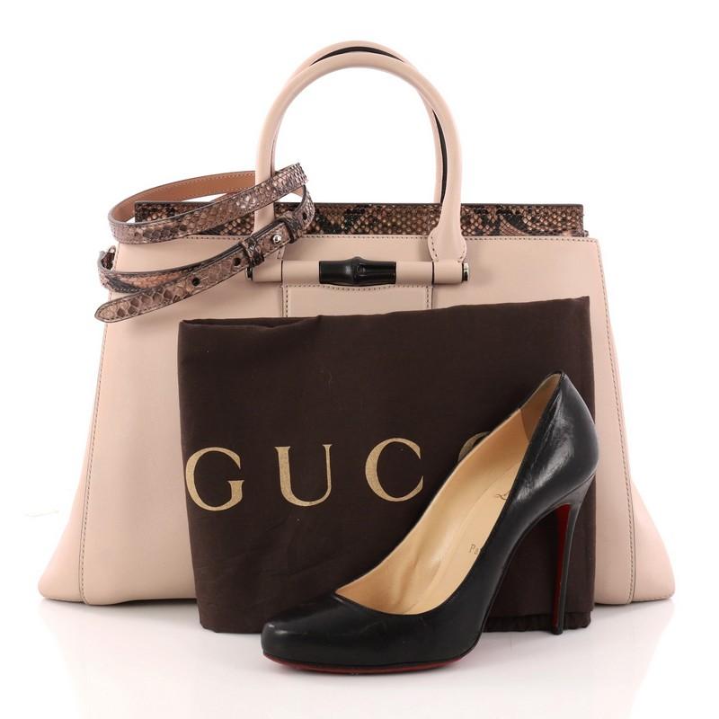 This authentic Gucci Lady Bamboo Top Handle Bag Leather and Python showcases a simple, minimalist silhouette with an exotic flair. Crafted from nude leather with genuine brown python trims, this elegant handle bag features dual-rolled leather