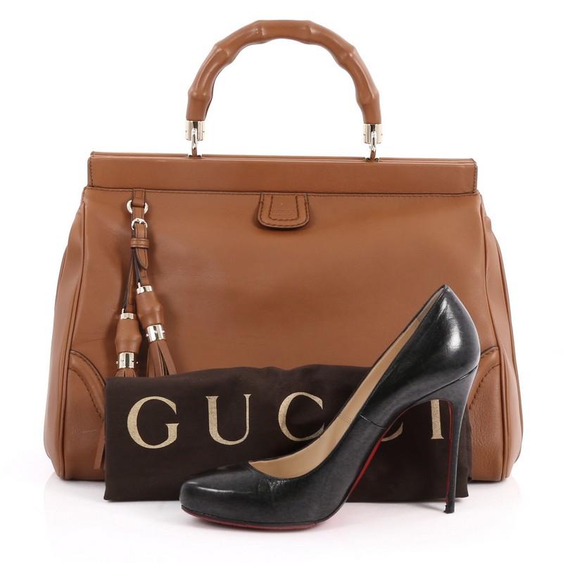 This authentic Gucci Bold Bamboo Top Handle Bag Leather presented in the brand's 2014 Collection mixes modern aesthetic with traditional Gucci flair. Crafted in supple brown leather, this soft-structure, oversized tote features a signature
