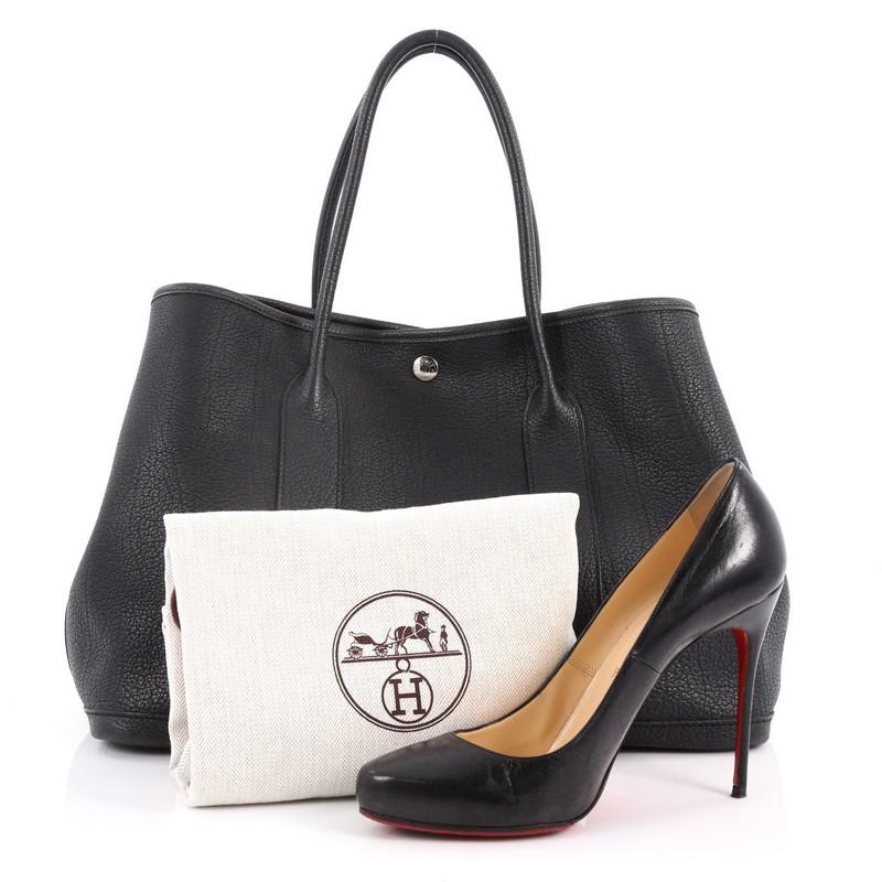 This authentic Hermes Garden Party Tote Leather 36 is an elegant and simple tote bag made for all seasons. Crafted from sturdy black leather, this chic everyday tote features dual-rolled top handles, palladium button closure, side snap buttons and