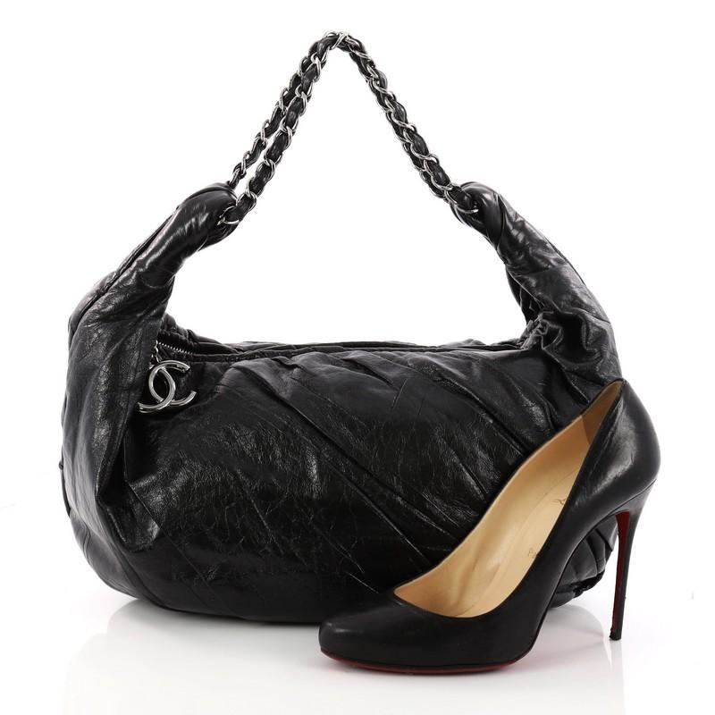 This authentic Chanel Twisted Hobo Glazed Calfskin Large is an eye-catching, distinct design loved by Chanel enthusiasts anywhere. Crafted from black twisted glazed calfskin leather sewn together, this no-fuss, elegant hobo features woven-in leather