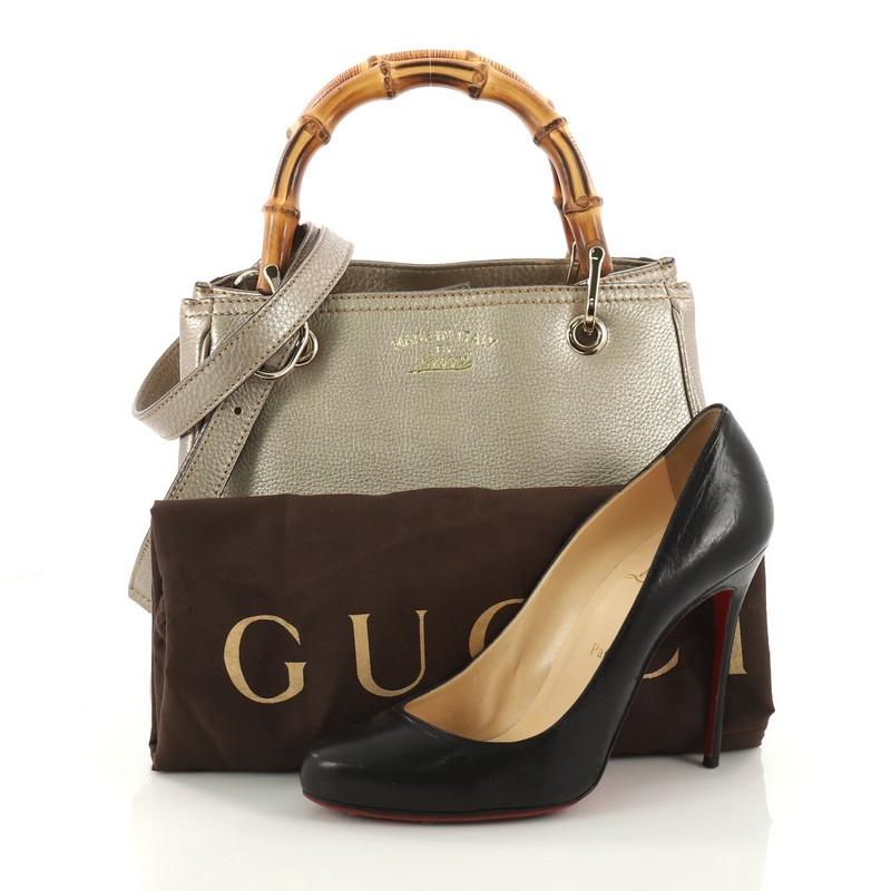 This authentic Gucci Bamboo Shopper Tote Leather Small is a classic must-have. Crafted in gold metallic leather, this simple yet stylish tote features Gucci's signature sturdy bamboo handles, protective base studs, stamped logo at the front and
