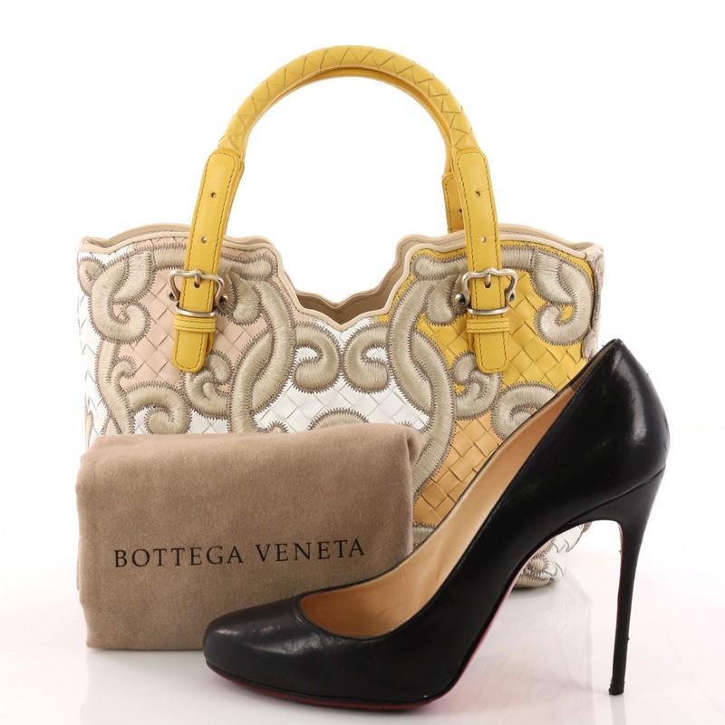 This authentic Bottega Veneta Belted Tote Embroidered Intrecciato Nappa Medium is a statement piece perfect for to add to your collection. Crafted in multicolor nappa leather woven in Bottega Veneta's signature intrecciato method, this stylish tote