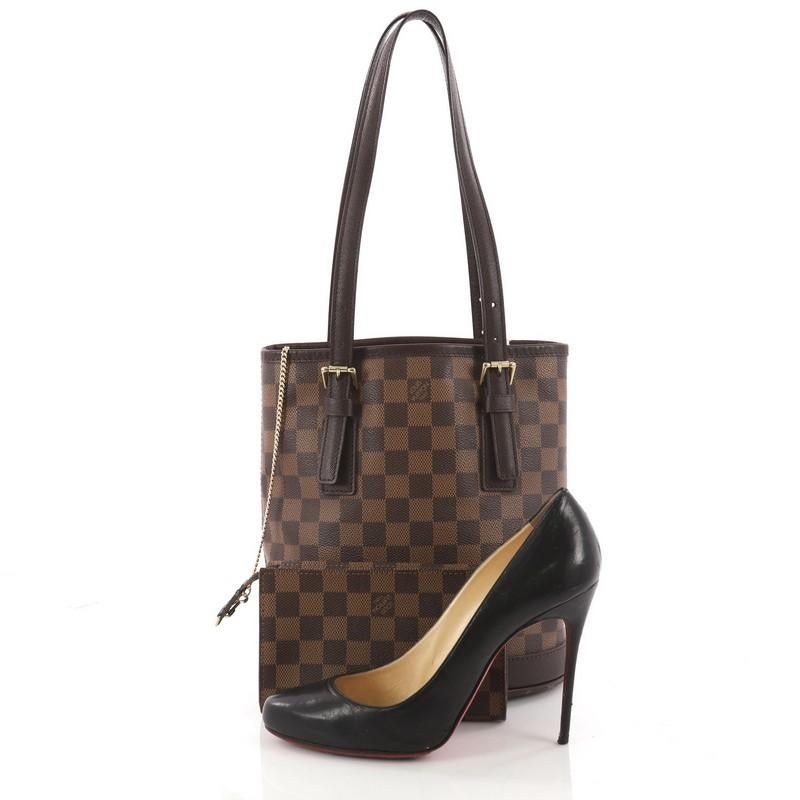 This authentic Louis Vuitton Marais Bucket Bag Damier showcases a simple and chic design making it an ideal accessory for all seasons. Crafted from the brand's signature damier ebene coated canvas, this bucket bag features dual tall leather handles