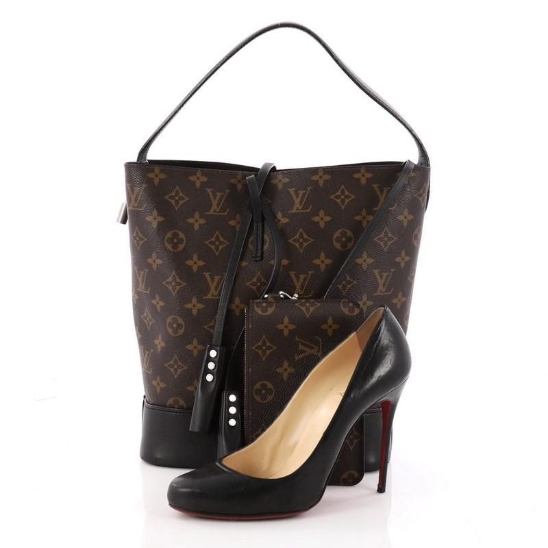 This authentic Louis Vuitton NN14 Idole Bucket Bag Monogram Canvas and Leather GM is a refreshed version of the iconic Noe bag. Crafted from brown monogram coated canvas with black calfskin leather trims, this bag features hand-pleated leather