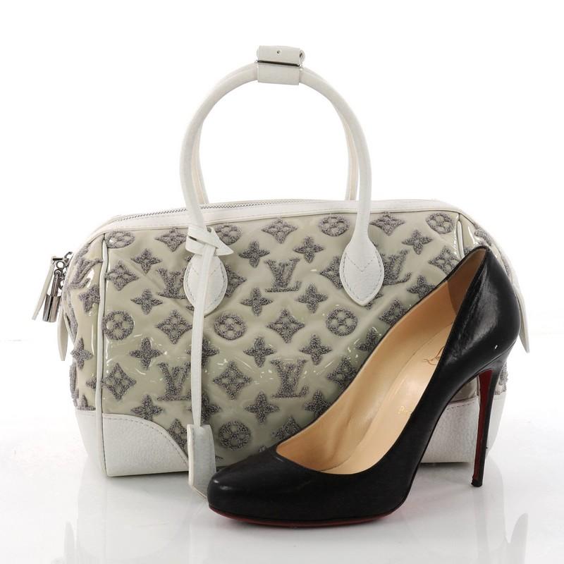 This authentic Louis Vuitton Round Speedy Bag Monogram Bouclettes is great for everyday wear and perfect for the modern fashionista. Crafted in grey monogram bouclette, this limited edition bag features and white calfskin trims, dual-rolled leather