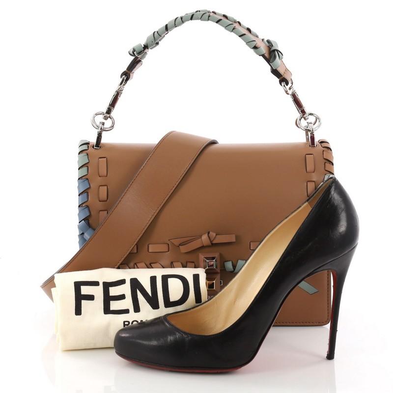 This authentic Fendi Kan I Bow Handbag Whipstitch Leather Medium is a uniquely designed bag perfect for the stylish fashionista. Crafted from brown leather, this bag features contrasting studs in the characteristic bow design, whipstitch top leather