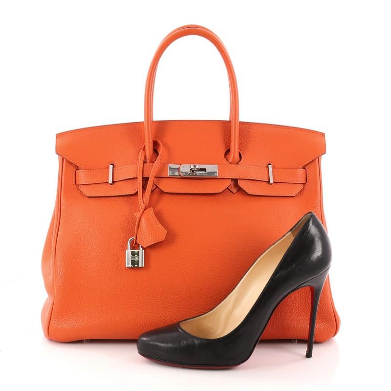 This authentic Hermes Birkin Handbag Orange H Vache Trekking with Palladium Hardware 35 is synonymous to traditional Hermes luxury. Crafted with sturdy, scratch-resistant Orange H leather, this eye-catching tote features dual-rolled top handles, a