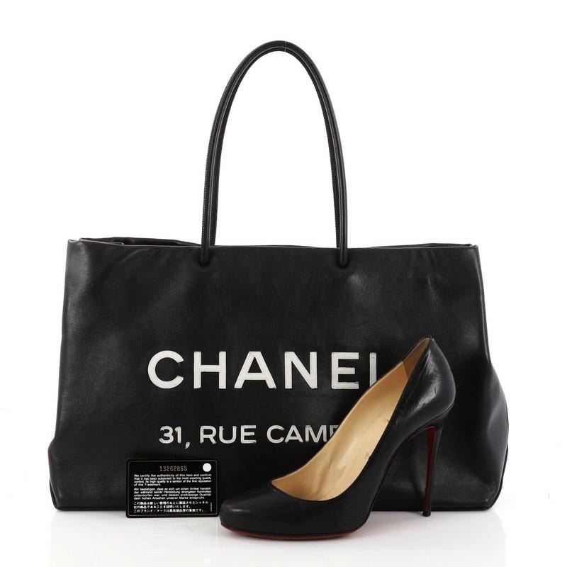 This authentic Chanel Essential 31 Rue Cambon Shopping Tote Leather Medium is a minimalist shopping bag perfect for toting all of your belongings. Crafted in black leather, this chic bag features dual-rolled slim leather handles, Chanel logo and