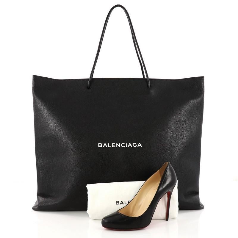 This authentic Balenciaga Shopping Tote Leather East West is the perfect companion on your daily excursions. Crafted in black leather, this bag features rolled leather handles, stamped with a sleek white logo at the front and silver-tone hardware