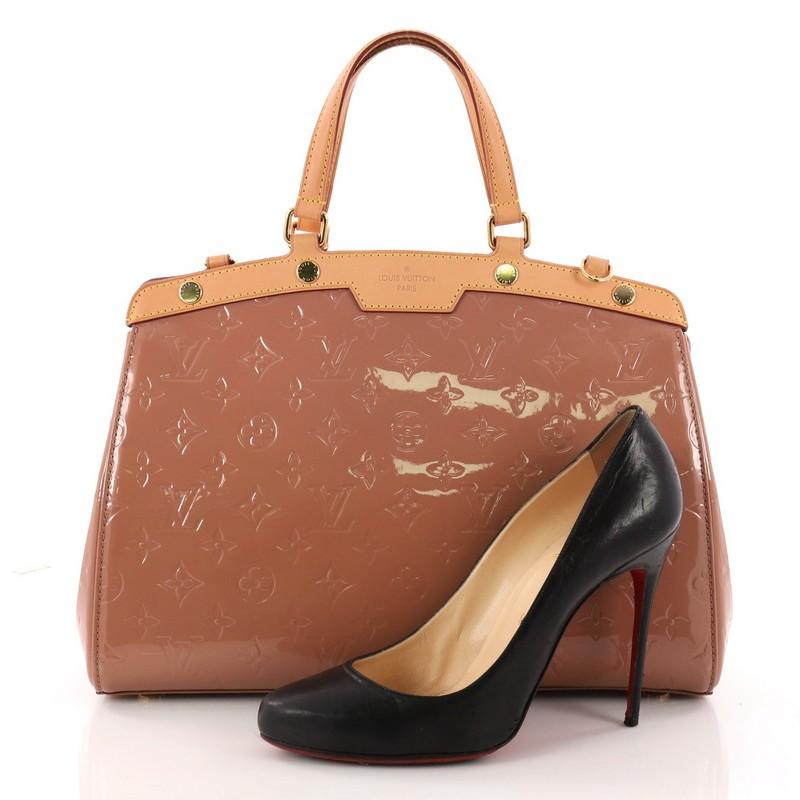 This authentic Louis Vuitton Brea Handbag Monogram Vernis MM is a staple for an everyday casual look. Crafted in pink monogram vernis leather with cowhide leather trims, this structured yet feminine tote features dual flat handles, protective base