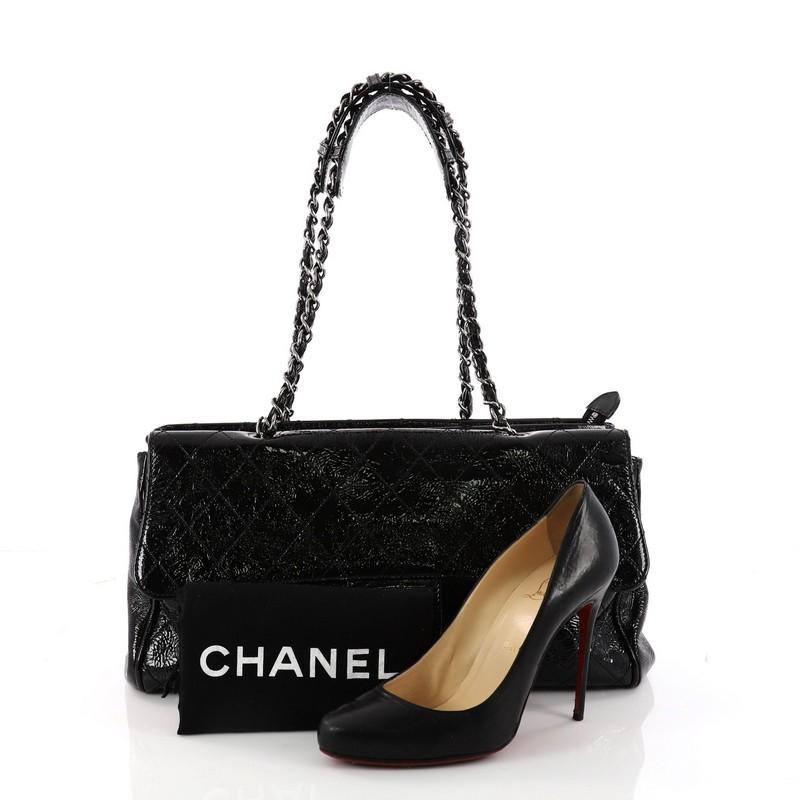 This authentic Chanel Ritz Flap Bag Quilted Patent Large presents an elegant yet versatile style made for everyday excursions. Crafted from black diamond quilted patent leather, this oversized tote features dual woven-in leather chain straps with