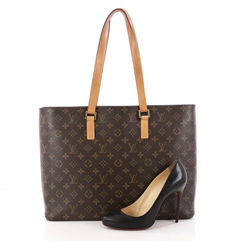This authentic Louis Vuitton Luco Handbag Monogram Canvas is a classic tote that displays fashion and functionality all rolled into one. Crafted with the brand's iconic brown monogram coated canvas, this tote features dual flat leather handles, a