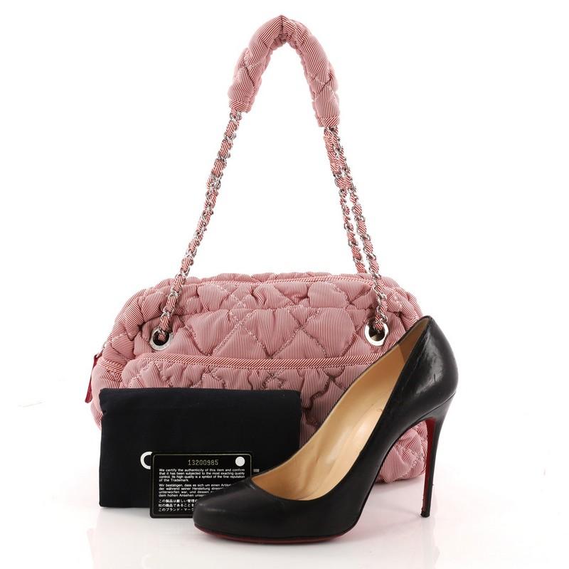 This authentic Chanel Bubble Chain Shoulder Bag Quilted Nylon Medium showcases a very stylish twist on its classic design made for everyday use. Crafted from pink quilted bubble nylon, this chic bag features chain-link shoulder strap fastened by a