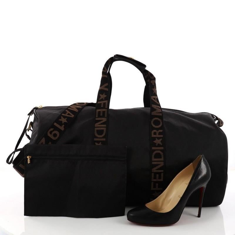 This authentic Fendi Vintage Logo Duffle Bag Nylon Large is ideal for weekend getaways. Crafted from black nylon, this duffle bag features dual printed top handles and adjustable strap and gold-tone hardware accents. Its zip closure opens to a