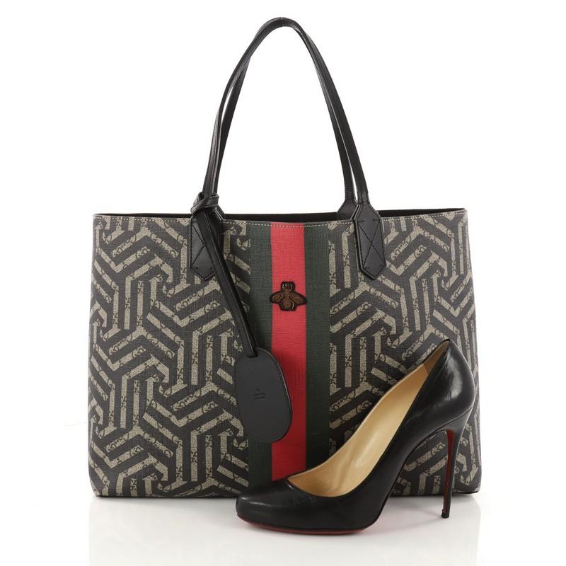This authentic Gucci Bee Web Shopping Tote Caleido Print GG Coated Canvas Medium is a unique bag perfect for your everyday excursions. Crafted in brown caleido printed GG coated canvas, this bag features dual slip leather handles, web detailing with