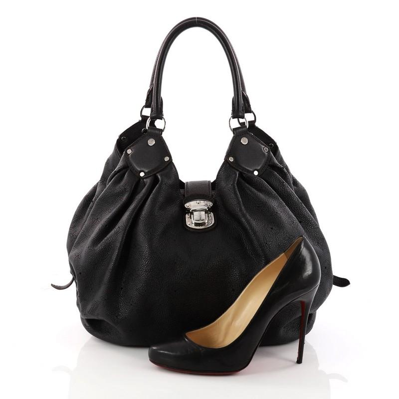 This authentic Louis Vuitton L-Hobo Mahina Leather is sleek and refined in design apt for the modern woman. Crafted in black perforated monogram mahina leather, this feminine hobo features dual-rolled handles, buckle and stud details, side belt