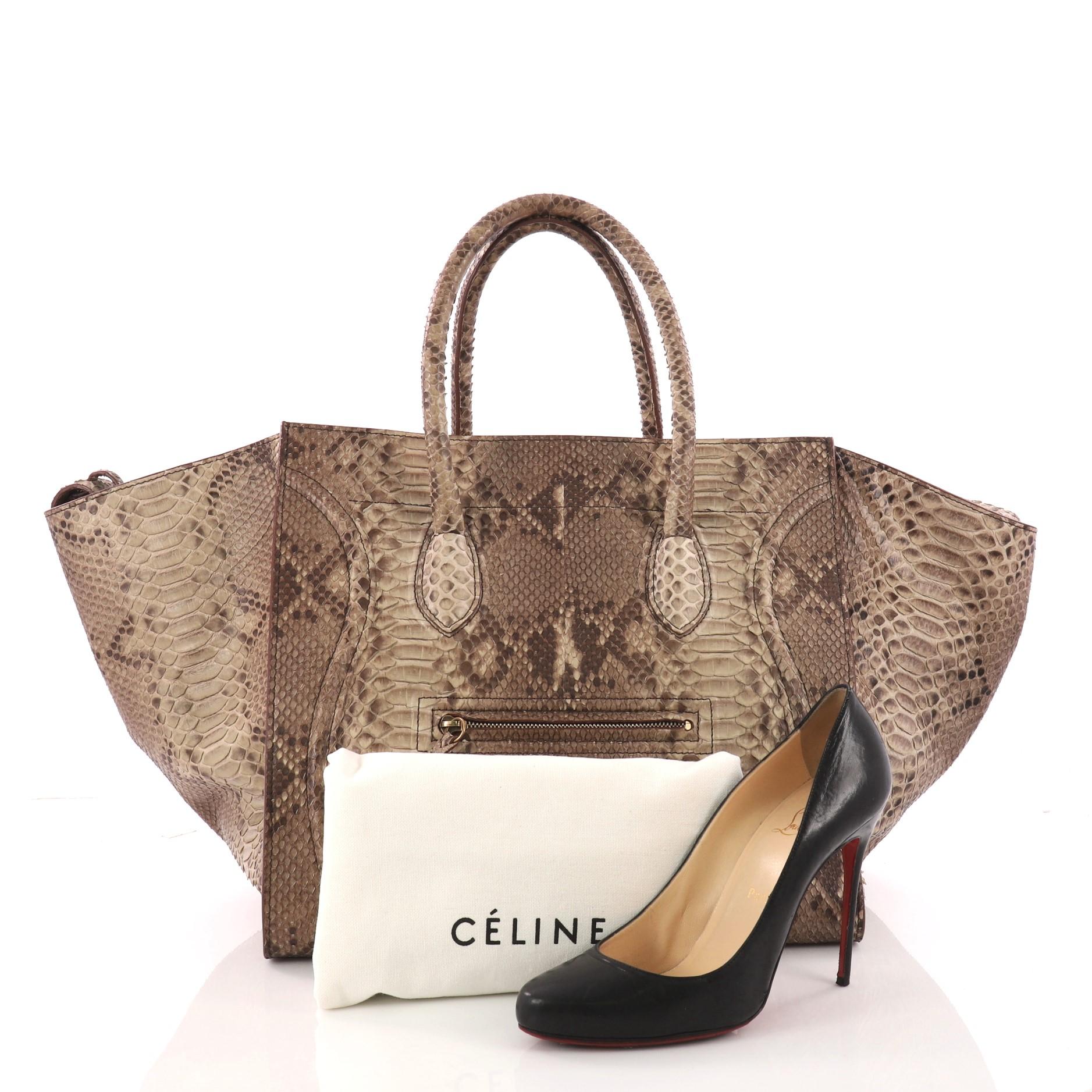 This authentic Celine Phantom Handbag Python Large is one of the most sought-after bags beloved by fashionistas. Crafted from genine brown python skin, this minimalist tote features dual-rolled handles, an exterior front pocket, protective base
