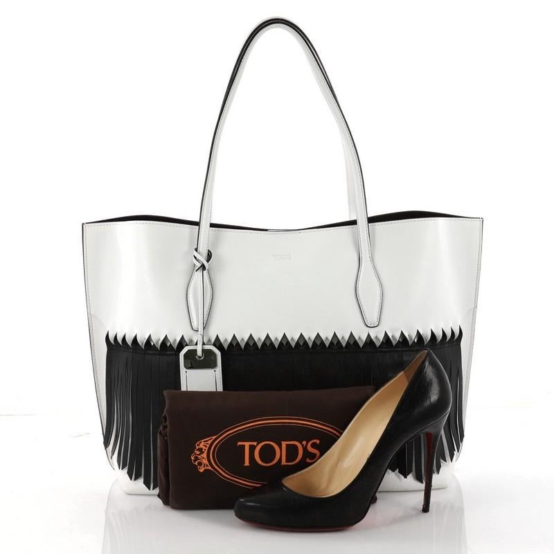 This authentic Tod's Fringe Joy Tote Leather Large showcases the brand's minimalist casual style that makes a perfect everyday carryall. Crafted from white leather, this versatile tote features dual-slim leather handles, black leather fringe