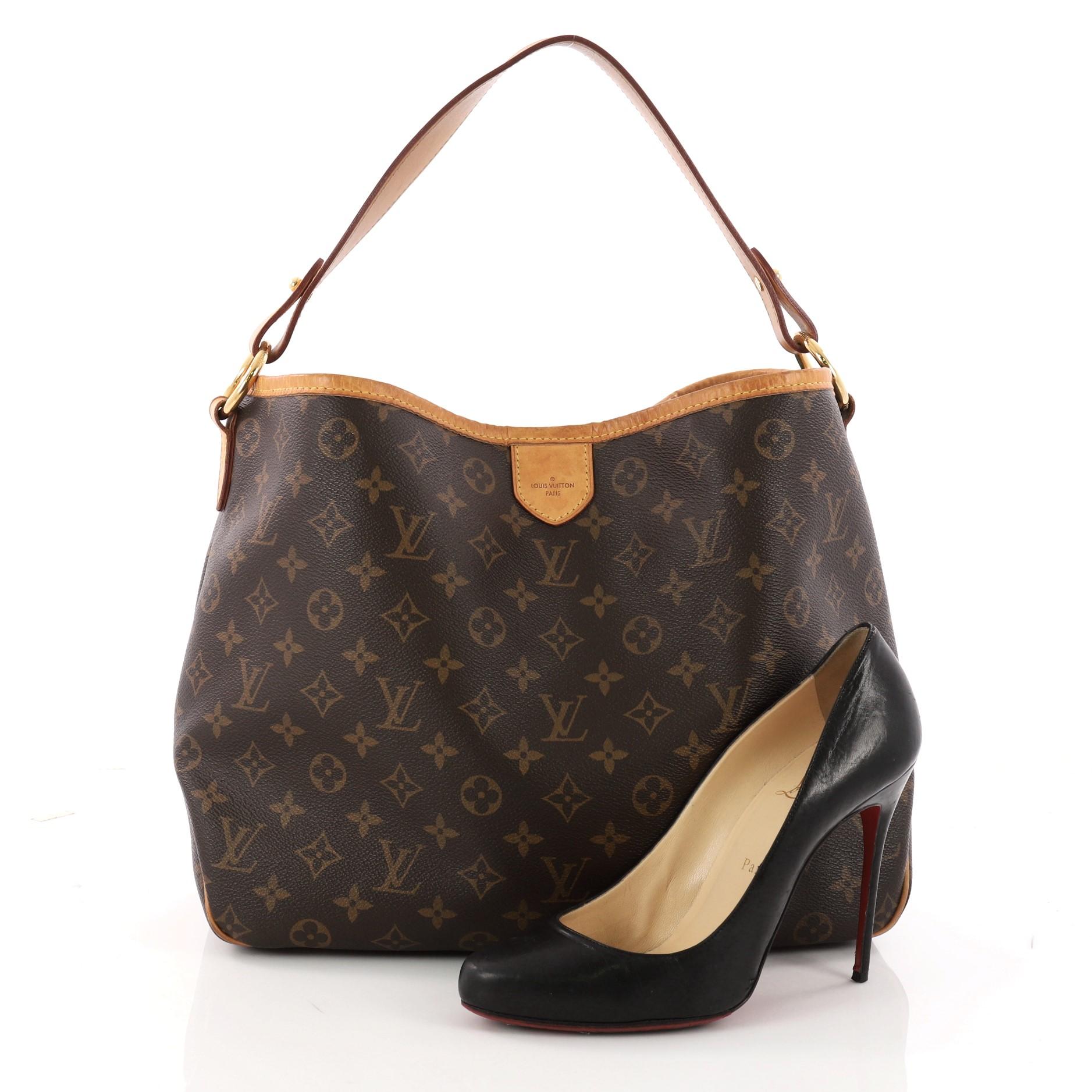This authentic Louis Vuitton Delightful Handbag Monogram Canvas PM is a versatile hobo that can be used everyday. Constructed from the brand's classic brown monogram coated canvas with cowhide leather trims, this glamorous bag features flat leather
