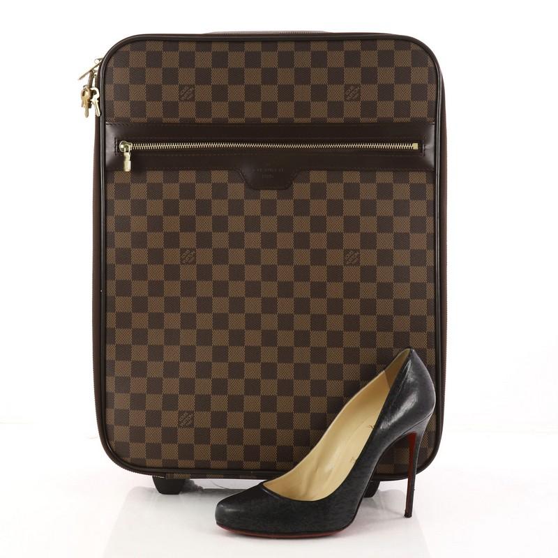 This authentic Louis Vuitton Pegase Luggage Damier 45 is a sleek and sturdy suitcase for all your travels. Crafted from Louis Vuitton's iconic damier ebene coated canvas, this bag features exterior zip pocket, retractable handle with lock button, a