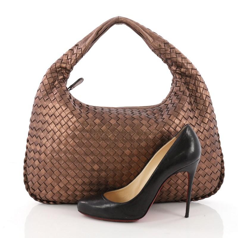 This authentic Bottega Veneta Belly Hobo Intrecciato Nappa Medium is a timelessly elegant bag with a casual silhouette. Excellently crafted from brown bronze metallic leather woven in Bottega Veneta's signature intrecciato method, this no-fuss hobo
