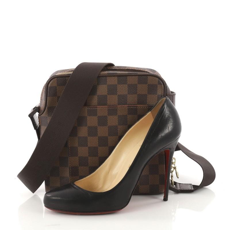 This authentic Louis Vuitton Olav Handbag Damier PM is perfect for the style-conscious man or woman. Crafted from damier ebene coated canvas, this bag features an adjustable textile strap with Louis Vuitton embroidery, exterior flat pocket and