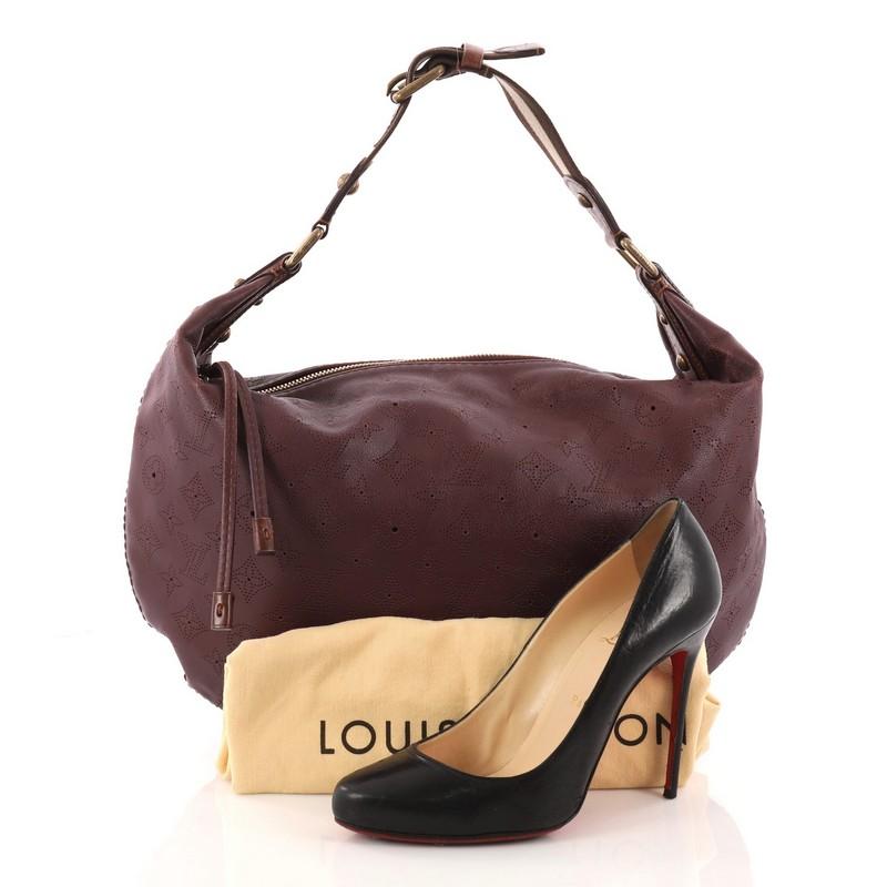 This authentic Louis Vuitton Onatah Hobo Mahina Leather GM is a stylish and functional must-have bag for LV lovers. Crafted from the brand's signature purple monogram mahina leather, this hobo features adjustable textile stripe strap with purple