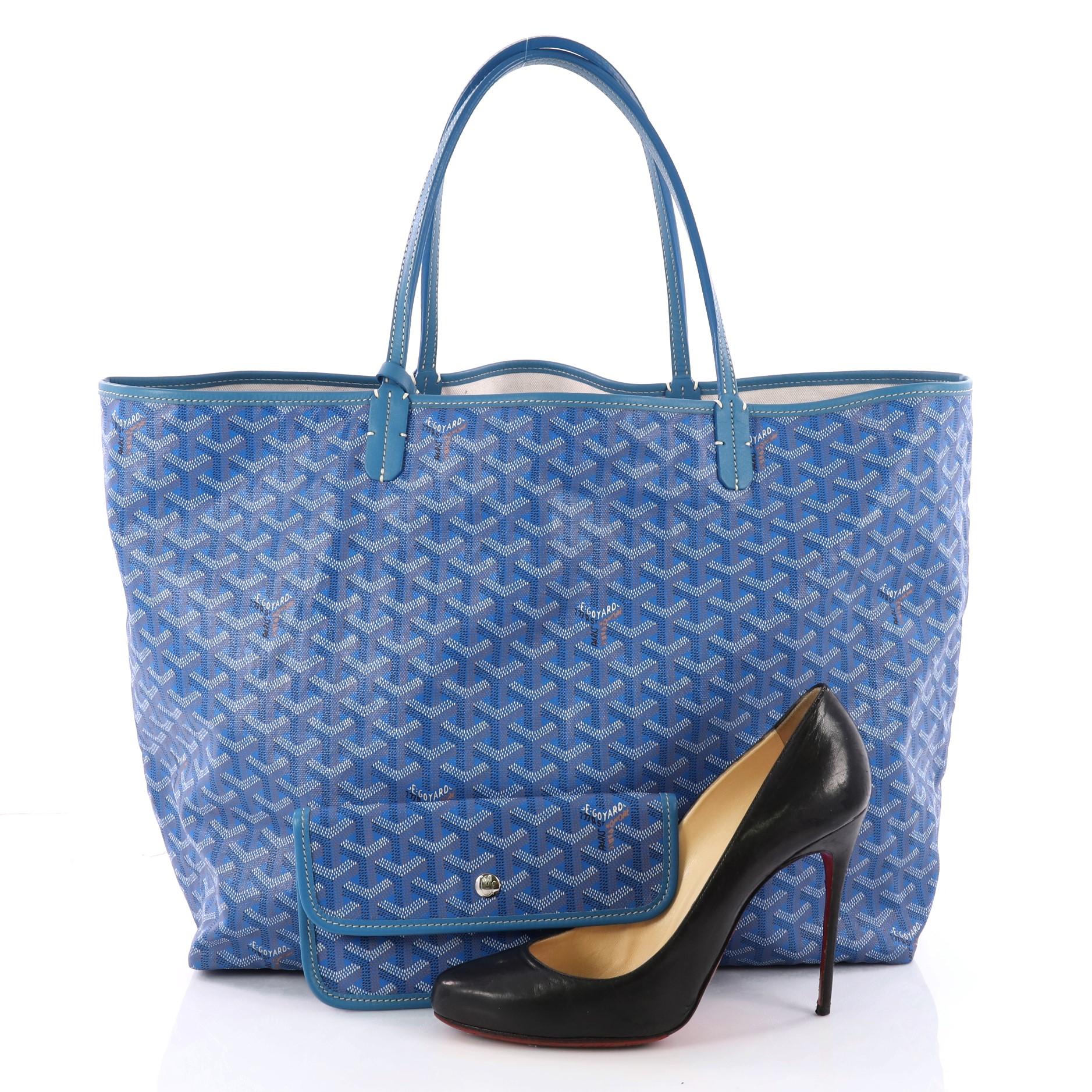 This authentic Goyard St. Louis Tote Coated Canvas GM is a spacious bag ideal for everyday excursions. Crafted from the popular and traditional blue Goyard chevron printed coated canvas, this tote features long flat leather handles, stand-out