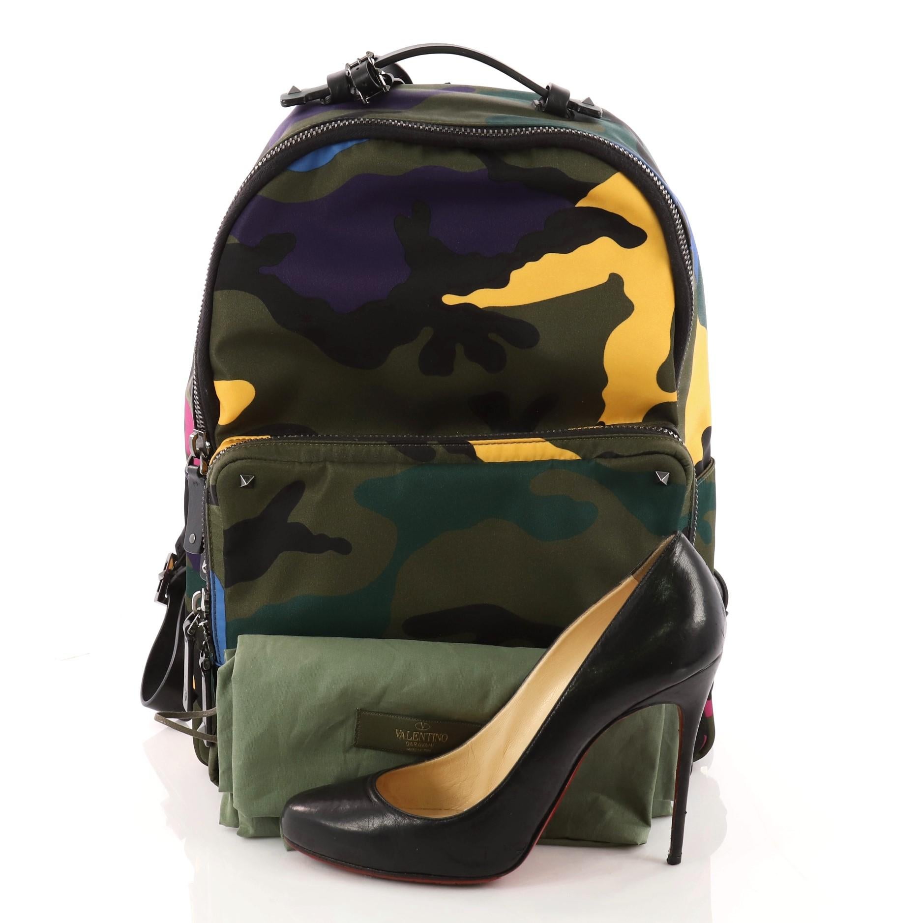This authentic Valentino Camouflage Backpack Nylon and Leather Large is a stylish backpack perfect for on-the go moments. Crafted in green camo print nylon, this practical bag features dual shoulder straps, stud detailing, exterior front zip pocket
