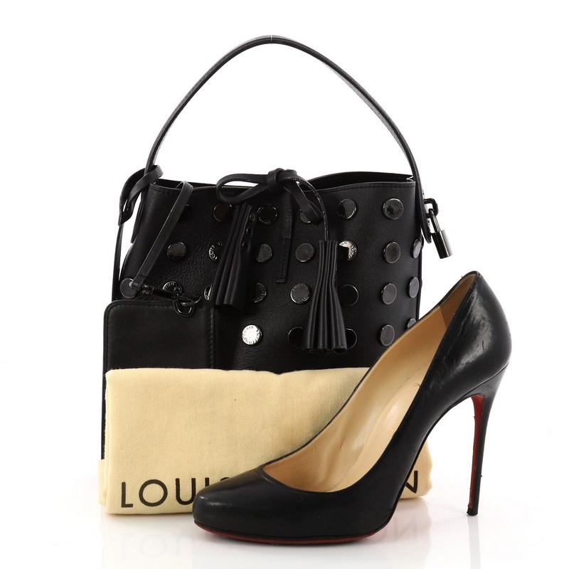 This authentic Louis Vuitton NN14 Audace Bucket Bag Calfskin PM gives a daring, rock ‘n’ roll vibe with a modern edge. Crafted in black leather with hand-applied blackened Louis Vuitton-engraved metal studs, this updated luxurious bucket bag