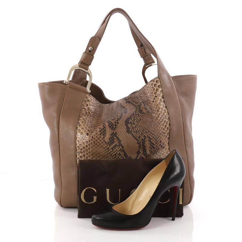 This authentic Gucci Greenwich Tote Python and Leather is perfect for any casual or sophisticated outfit. Crafted from brown leather with genuine python skin paneling, this tote features dual flat leather handles with spur detailing, and gold-tone
