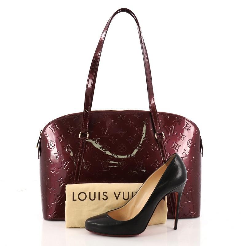 This authentic Louis Vuitton Avalon Zipped Handbag Monogram Vernis is a fresh and elegant spin on a classic style that is perfect for all seasons. Crafted from Louis Vuitton's burgundy monogram vernis patent leather, this dome-shaped tote features