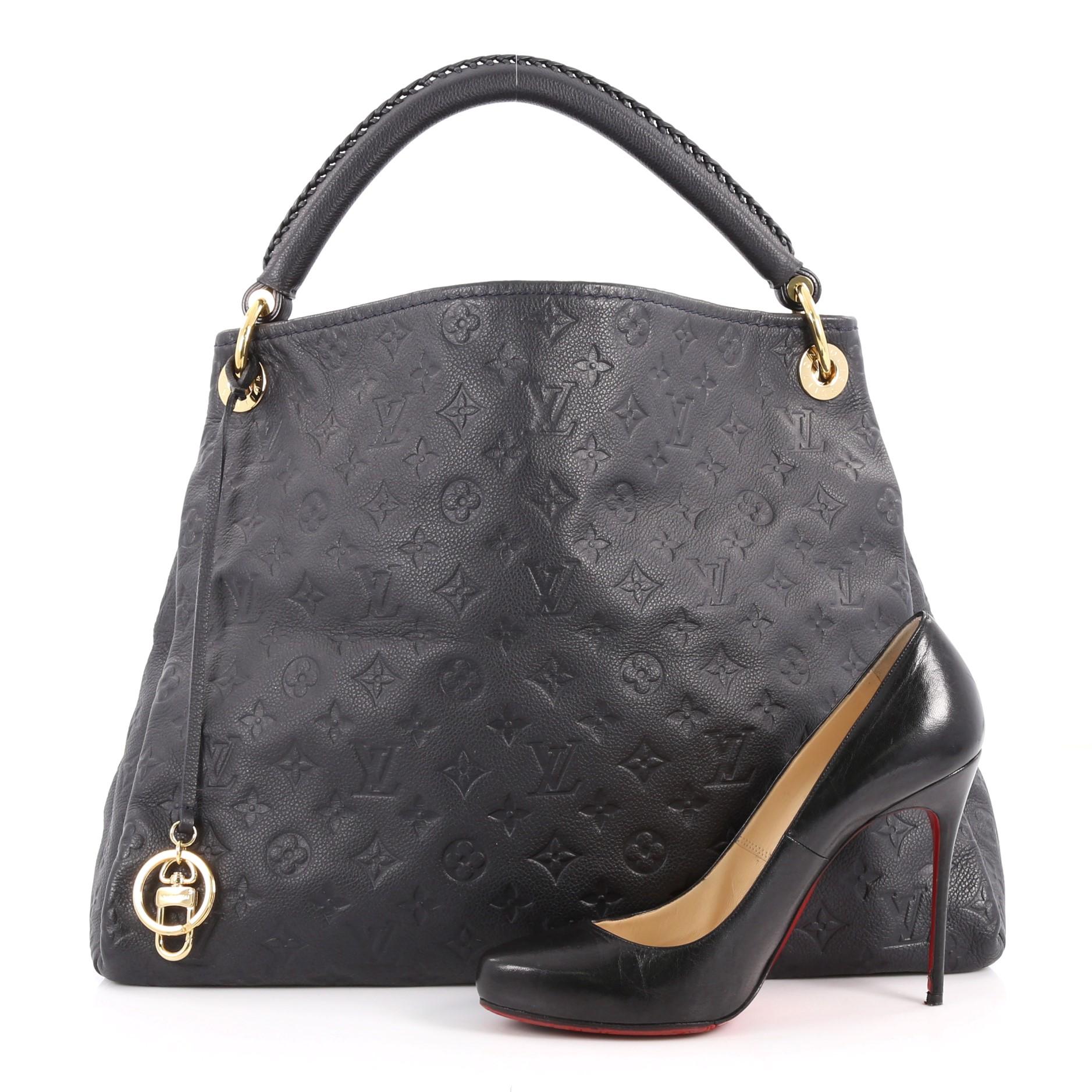 This authentic Louis Vuitton Artsy Handbag Monogram Empreinte Leather MM is an iconic hobo. Crafted from navy monogram embossed empreinte leather, this luxurious and refined hobo features a single looped braided top handle with polished gold links,