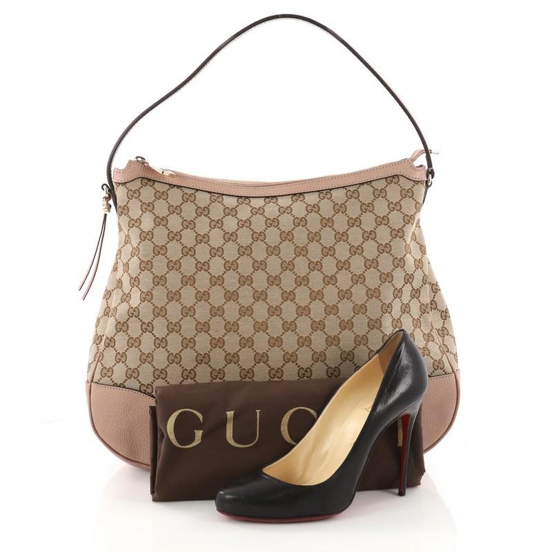 This authentic Gucci Bree Hobo GG Canvas with Leather Large is a chic and sophisticated bag that you won't pass out on. Crafted from brown GG canvas, this iconic bag features flat leather shoulder strap, pink leather trims, Gucci charms and
