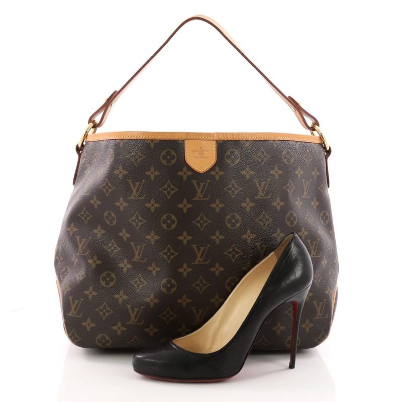This authentic Louis Vuitton Delightful Handbag Monogram Canvas PM is a versatile hobo that can be used everyday. Constructed from the brand's classic brown monogram coated canvas with cowhide leather trims, this glamorous bag features flat leather