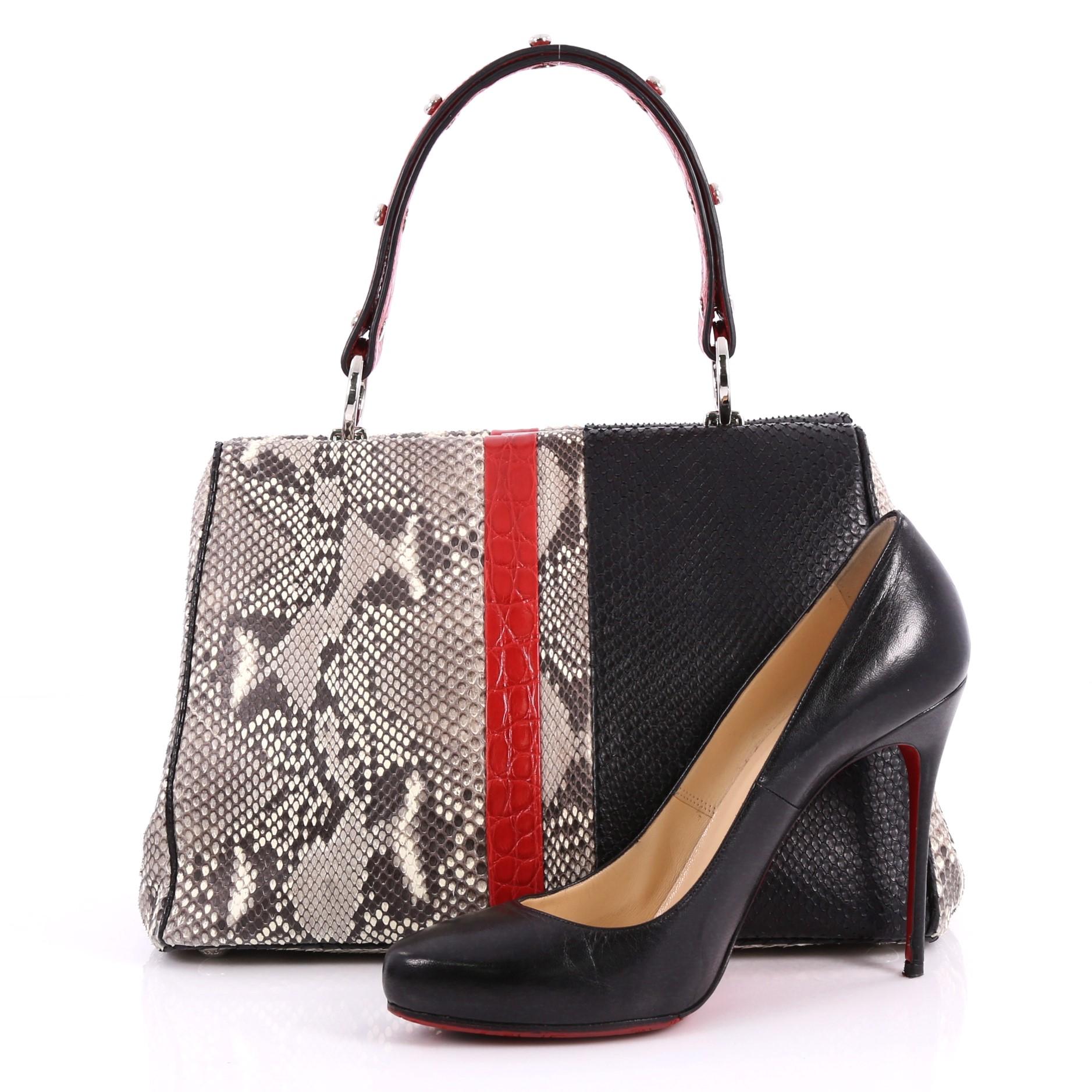 This Prada Baiadera Frame Bag Calfskin Small is a structured, vividly hued satchel perfect for the modern fashionista. Crafted from genuine gray and black python skin with red crocodile skin, this chic bag features studded top handle, frame top,