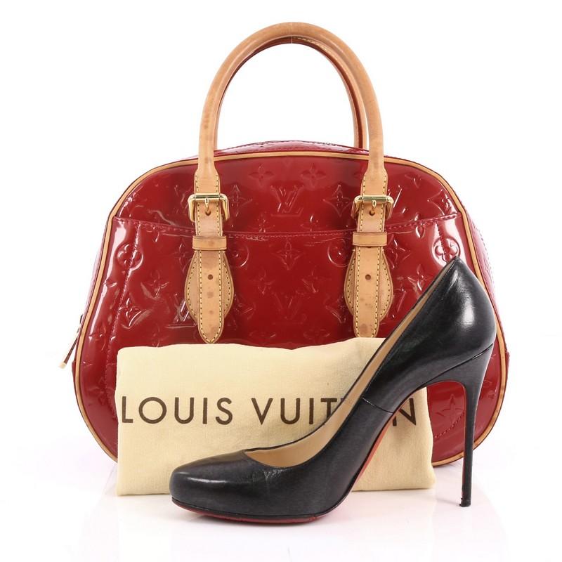 This authentic Louis Vuitton Summit Drive Handbag Monogram Vernis is perfect for on the go moments. Crafted in red monogram vernis leather, this structured satchel features dual-rolled vachetta leather belted handles and trims, exterior pockets and