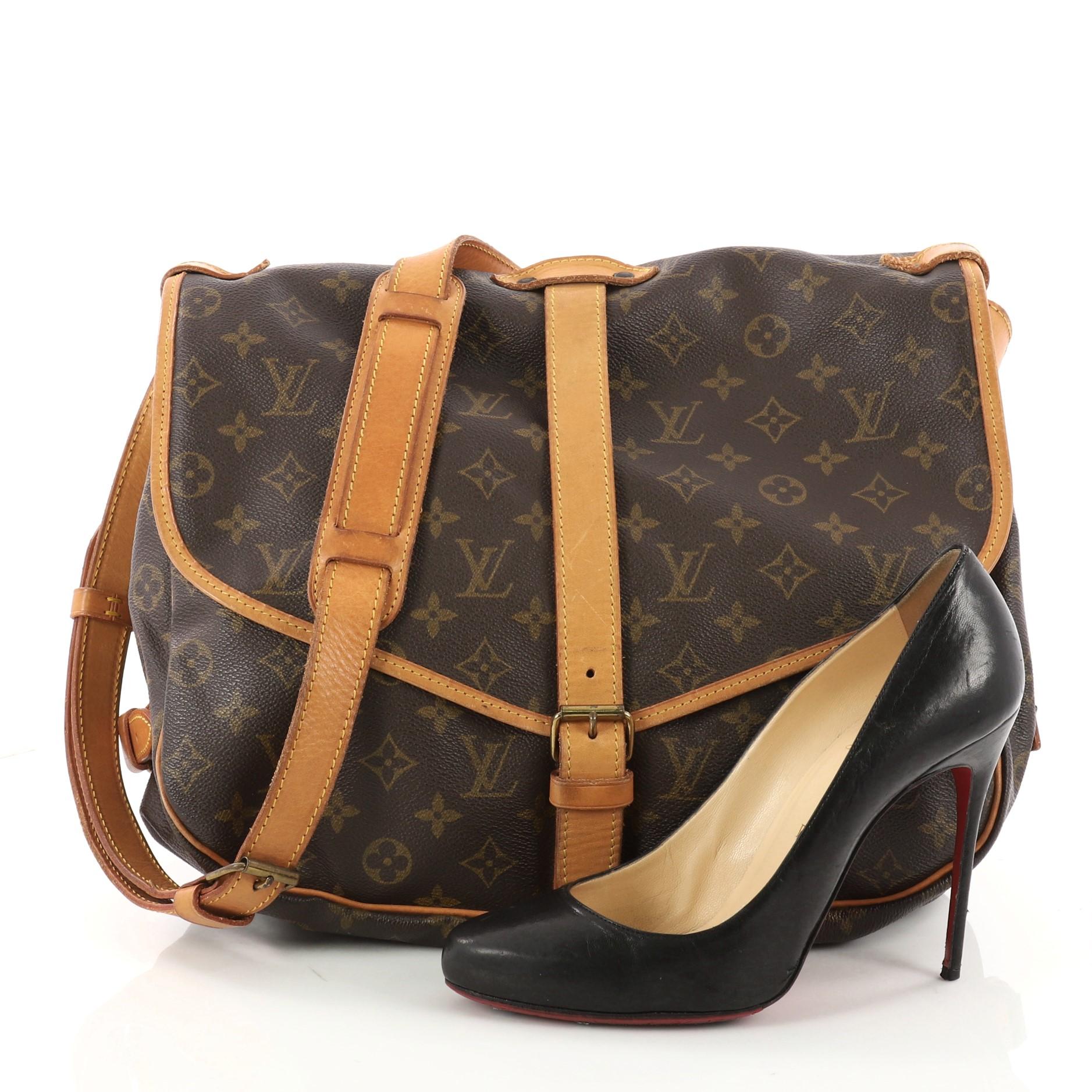 This authentic Louis Vuitton Saumur Handbag Monogram Canvas GM showcases the brand's reinterpretation of the classic saddle bag. Crafted in Louis Vuitton's brown monogram coated canvas, this bag features long adjustable shoulder strap, double saddle