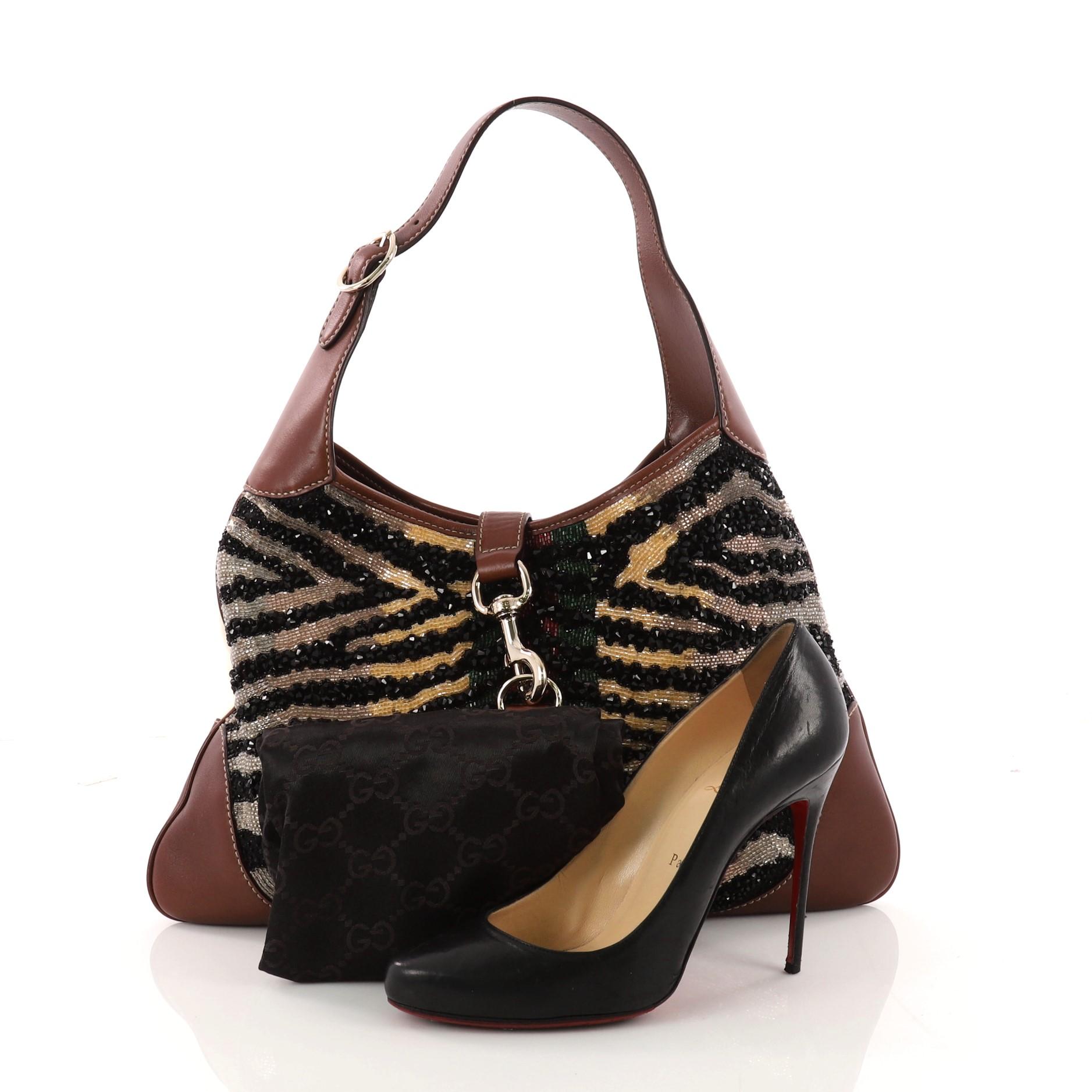 This authentic Gucci Jackie O Bouvier Web Hobo Embellished Leather Medium is a must-have luxurious hobo fit for the modern woman. Constructed from multicolor embellished leather and white suede, this chic hobo features an adjustable shoulder strap,