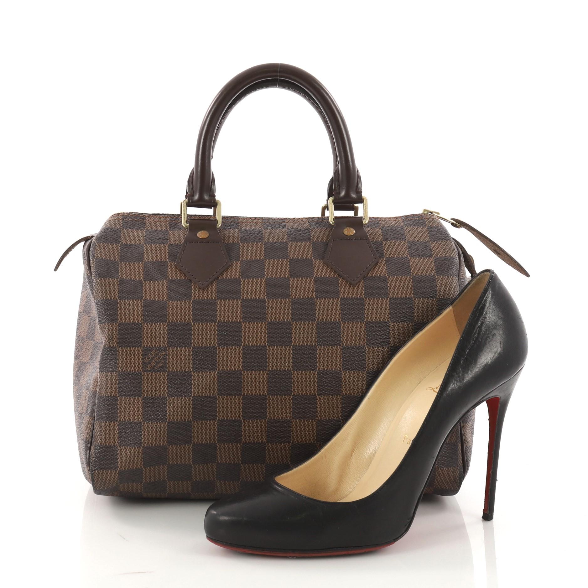 This authentic Louis Vuitton Speedy Handbag Damier 25 is a timeless favorite of many. Constructed from Louis Vuitton's signature damier ebene coated canvas, this iconic Speedy features dual-rolled handles, brown leather trims and gold-tone hardware
