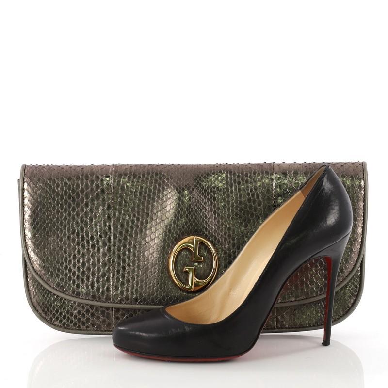 This authentic Gucci 1973 Clutch Python is understated and luxurious. Crafted in genuine metallic olive python skin, this chic clutch features double G logo at front flap, and gold-tone hardware accents. Its magnetic snap button closure opens to a
